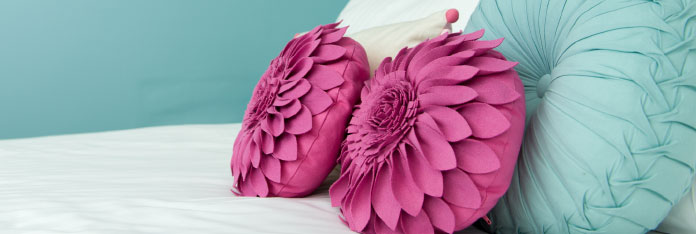 Pink and Blue Cushions on Bed